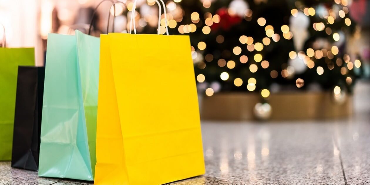 Einkaufstüten vor einem Weihnachtsbaum